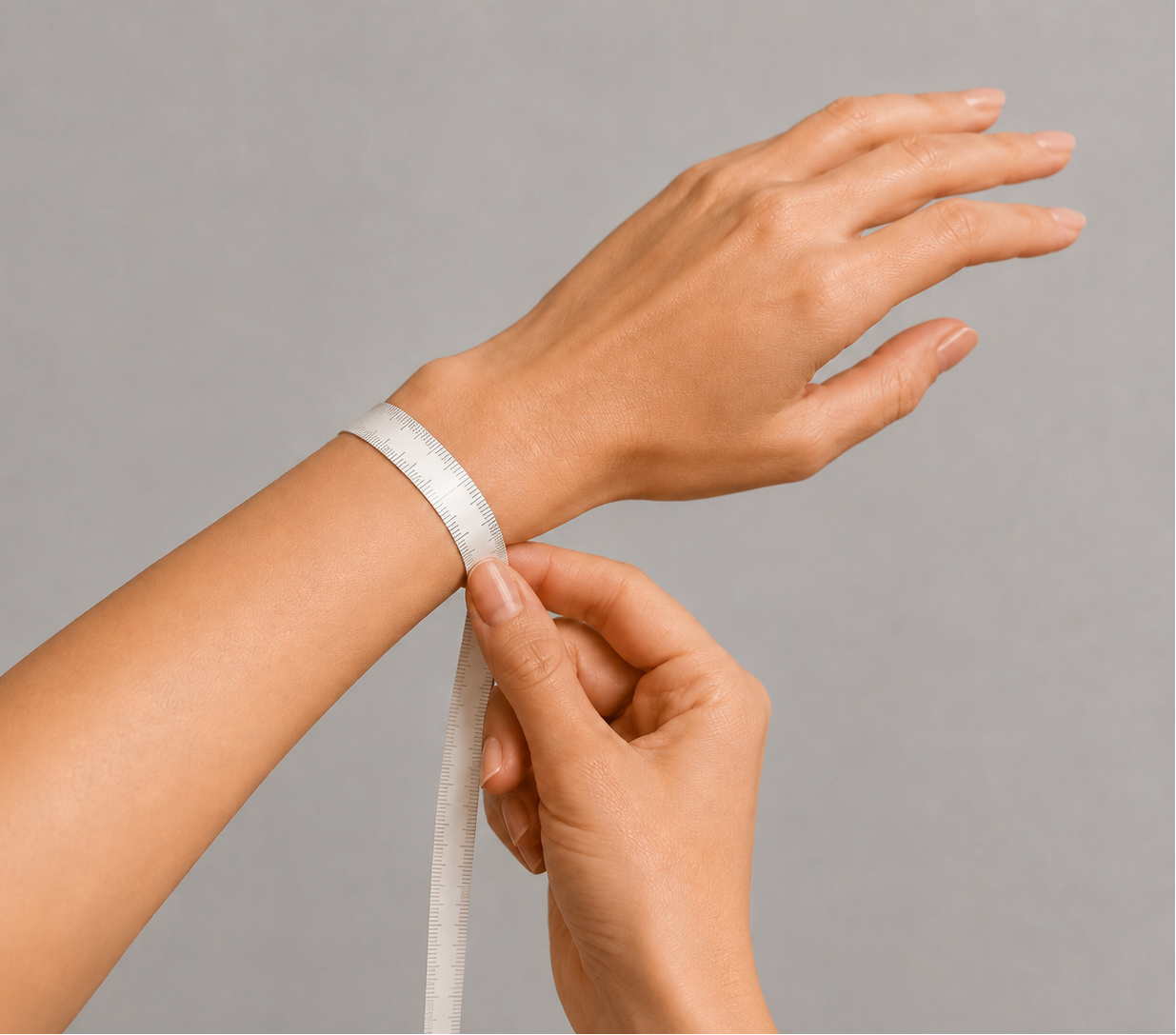 A close-up of a person's wrist and hand measuring a white elastic band with a tape measure against a plain gray background.